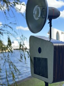 Moderne Fotobox mit Holzakzenten im Freien an der Spree für ein Sommerfest oder eine Outdoor Veranstaltung